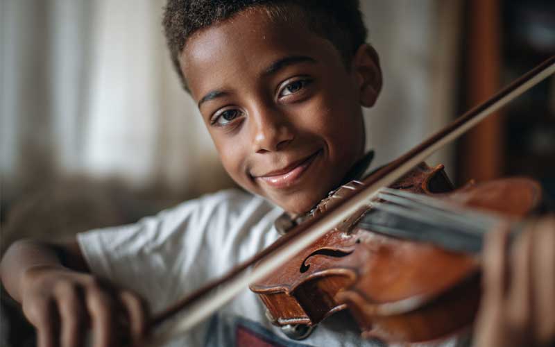 A young boy plays a violin
