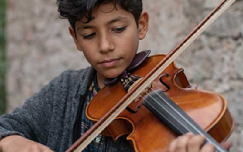 A young boy plays the viola